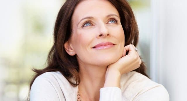 Woman looking up with her hand under her chin