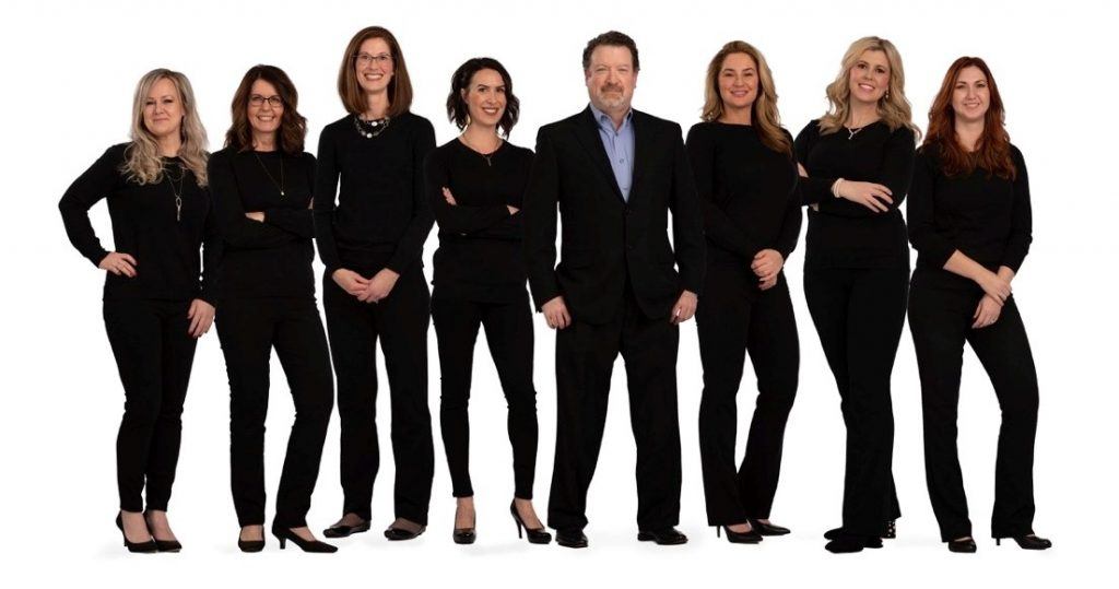 The Advanced Aesthetics team stands next to Dr. Kevin Johnson.