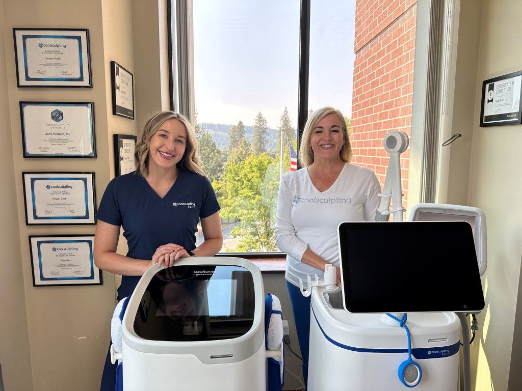 two staff members smiling behind coolsculpting device
