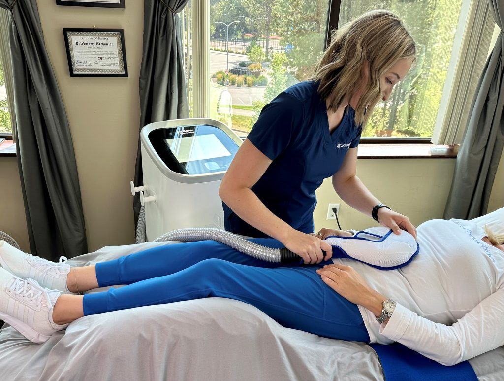 staff member performing cooltone treatment on patient