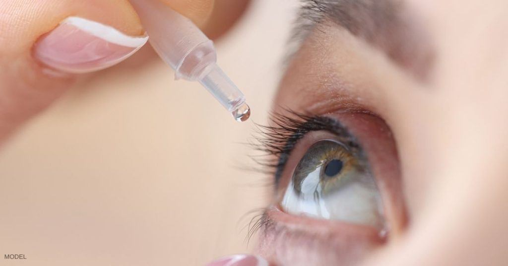 Close up of woman's eye (model) applying eye drops.