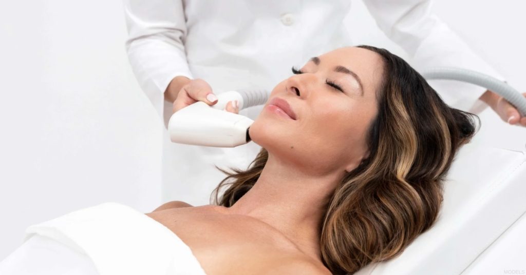 Woman receiving laser skin resurfacing treatment on her face (model).
