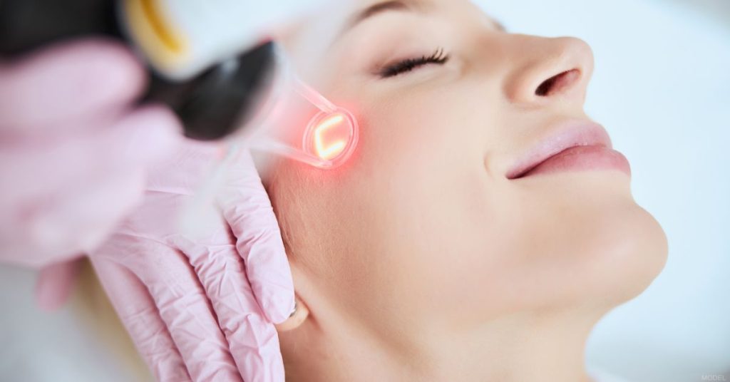 Close-up of a calm pleased woman undergoing laser skin treatment. (Model)